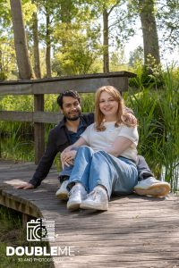 Een foto van een stel zittend op een steiger in het bos, gemaakt door Double Me