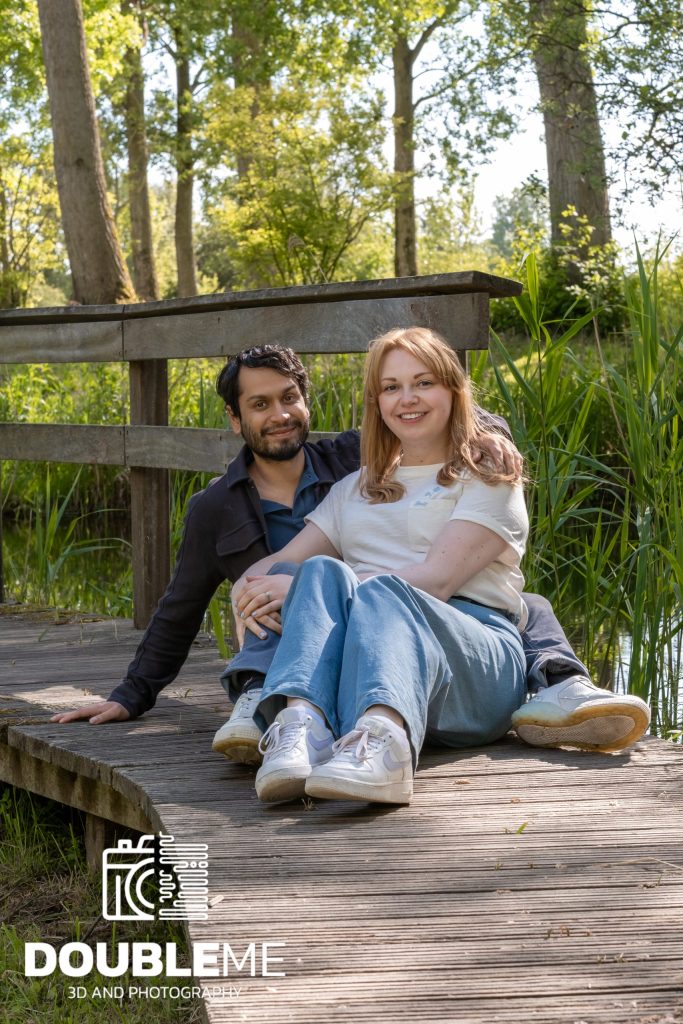 Een foto van een stel zittend op een steiger in het bos, gemaakt door Double Me